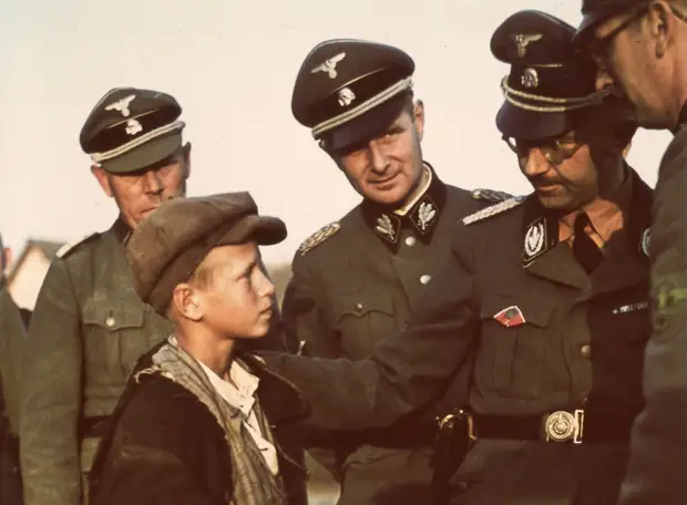 1941. Рейхсфюрер СС Генрих Гиммлер разговаривает с мальчиком из местных жителей во время инспекционной поездки по Белоруссии. Этот и еще один мальчик были отправлены в детский дом в Германию