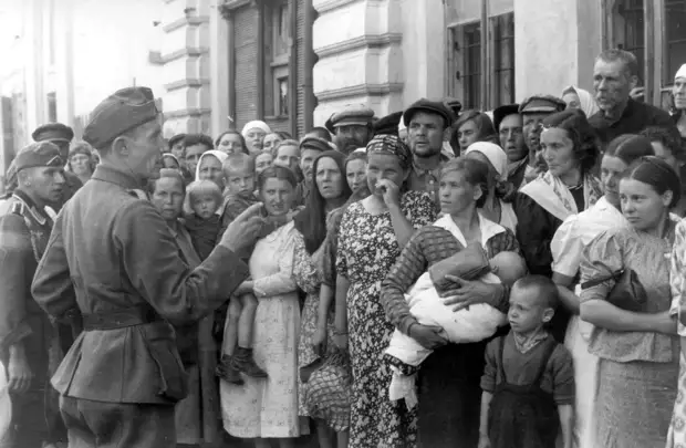 1941. Немецкий офицер обращается к стоящим в очереди местным жителям в оккупированном Могилеве