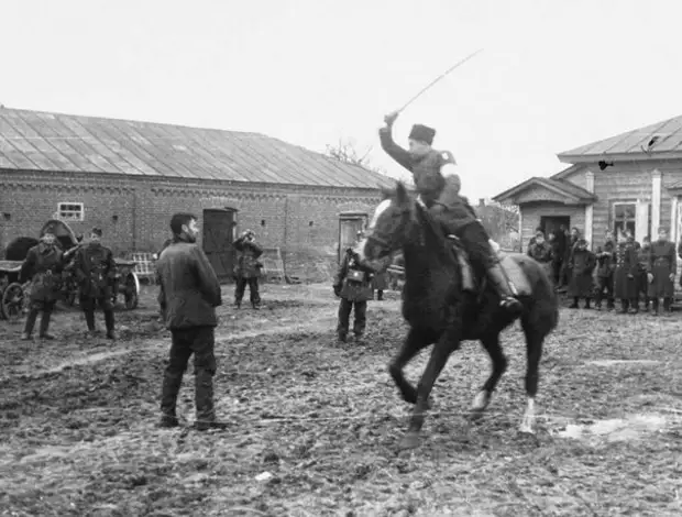Казак-полицай на потеху венгерским оккупантам рубит шашкой пленных советских партизан. Осень 1941 года, Украина.