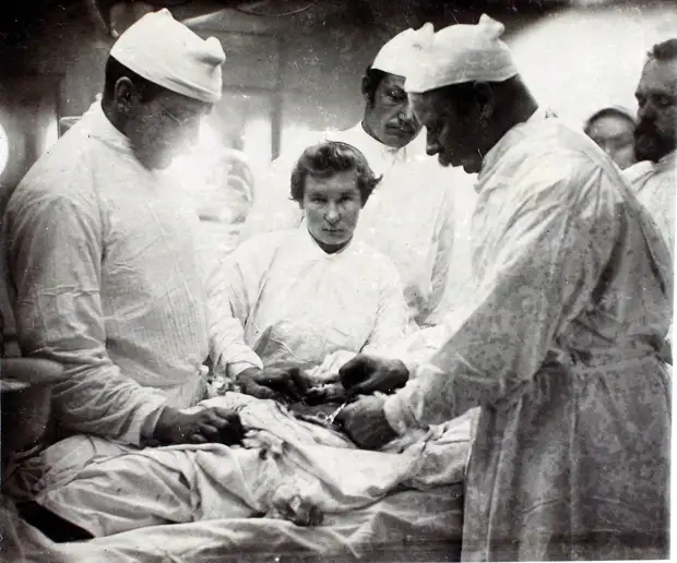 27. Старший врач И.Х. Дзирне (справа), врачи и сестры милосердия во время операции по удалению паховой грыжи. 1901