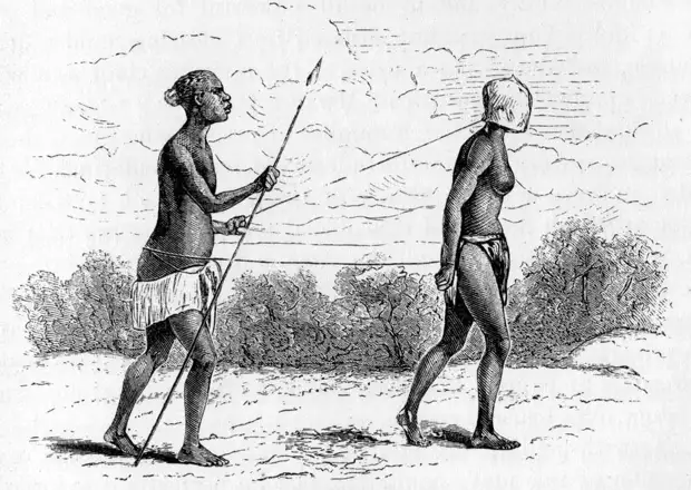 Негр-охранник конвоирует рабыню в маске (Восточная Африка, 1874 год)