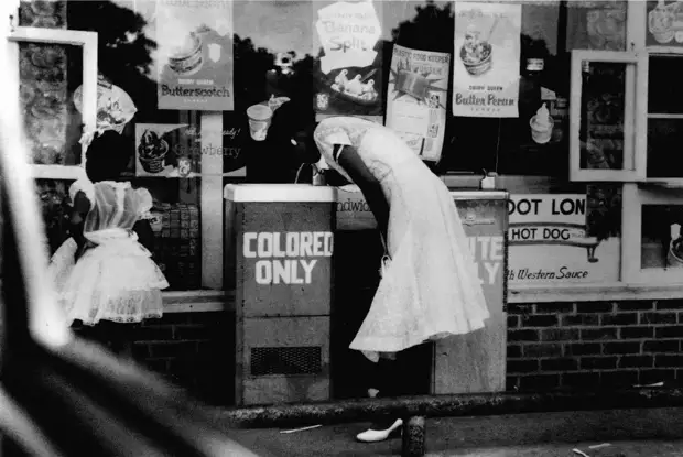 Афро-американская девушка у уличных питьевых фонтанчиков с надписями Только для белых и Только для цветных