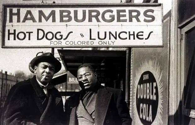 Два негра перед входом в кафе с надписью Гамбургеры и хот-доги. Только для цветных
