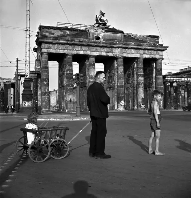 Германия, Берлин, 1947 год - Мужчина со своими детьми бродит возле Бранденбургских ворот